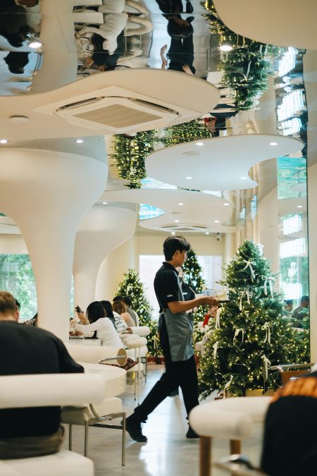 Festive Waiter/Waitress needed in Leeds Modern cafe interior during Christmas with festive decorations and customers dining.