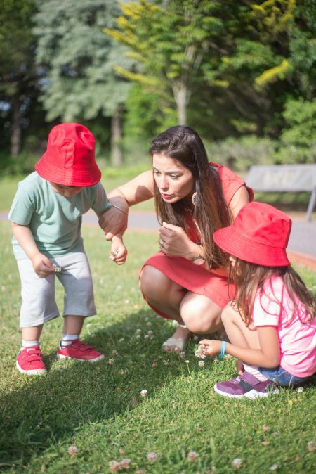 Back-up Nanny needed in Coventry Kids and nanny exploring nature in a sunny park setting, enjoying a learning moment.