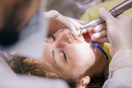 Close-up of a dental procedure with dentist and patient in a clinic setting.