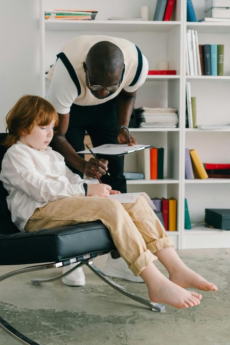 Educational Psychologist in Oxford (Visa Sponsorship Available) Therapist engaging with a child during session in a modern office.