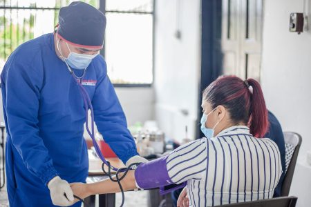 Community Public Health Nurse needed in South Gloucestershire (Visa Sponsorship Available) A nurse performs a blood pressure check on a patient in a healthcare setting, emphasizing safety and care.
