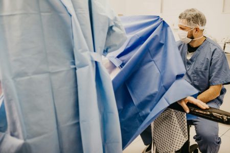 Healthcare professional in a delivery room, ready for surgery, illustrating a medical setup.