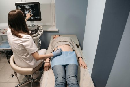 Midwife Band 5/6 needed in Gateshead (Visa Sponsorship Available) Healthcare professional performing an ultrasound scan on a patient in a medical clinic.