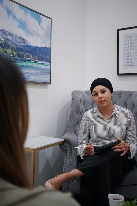 Therapist sits with client, fostering a supportive and understanding environment in an office.