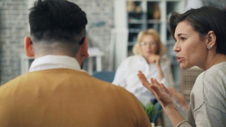 A therapist conducting a counseling session with a couple in an office setting.