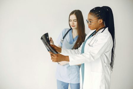 Two healthcare professionals review x-ray results in a clinical setting.